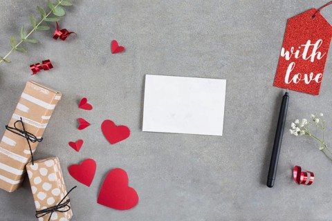 Present boxes near paper hearts sheet pen tag