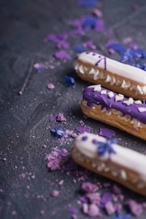 Purple macaroons with lavender flowers dark black background