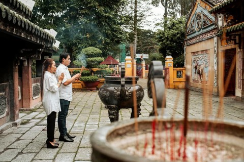 Side view man woman praying temple with burning incense