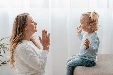 Side view mother praying with her child home