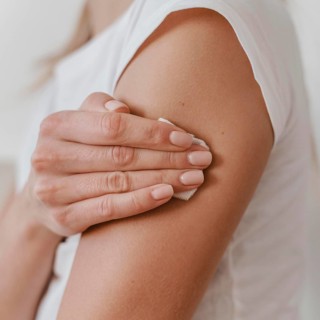 Side view woman holding her arm after getting her vaccine
