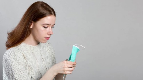 Side view woman holding medical mask her hands with copy space