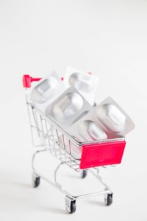 Sliver blister pills miniature shopping cart white background