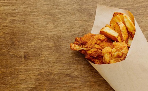 Top view fish chips paper wrap with copy space
