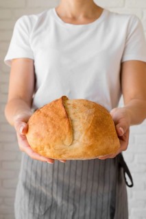 Woman holding fresh round bread