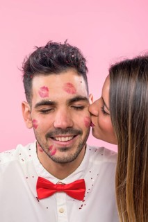 Woman kissing man with lipstick kiss marks cheek