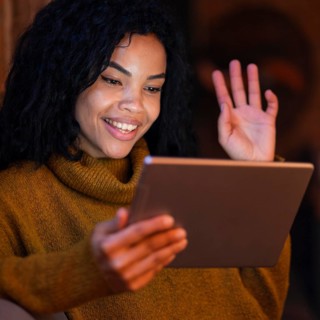Woman using tablet coffee shop video call