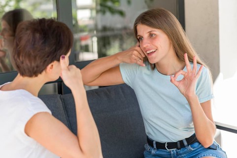 Women using sign language converse with each other