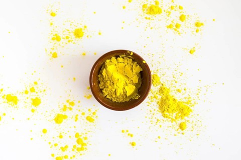 Yellow holi color powder bowl white background