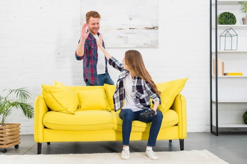 Young couple giving high five each other after playing video game