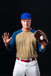 Baseball player with cap posing with glove