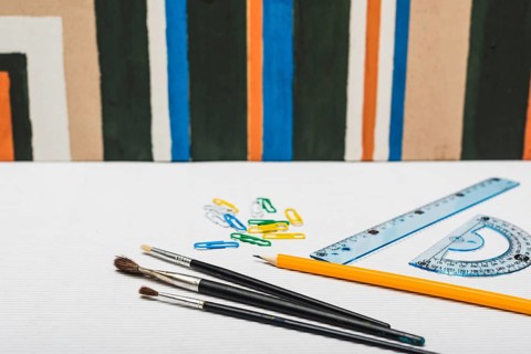 Brushes stationery near abstract painting