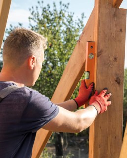 Carpenter man taking measures wood plank