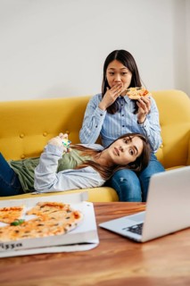 Chilling girls watching movie eating pizza