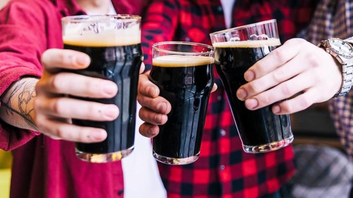 Close up friends clinking beer glasses