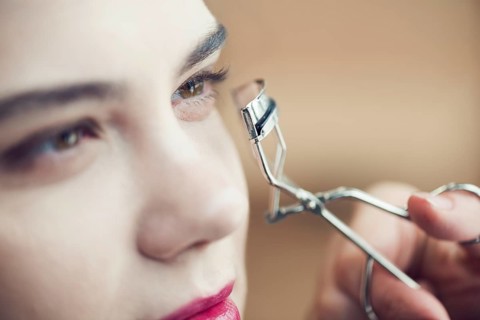 Close up hand curling eyelashes model