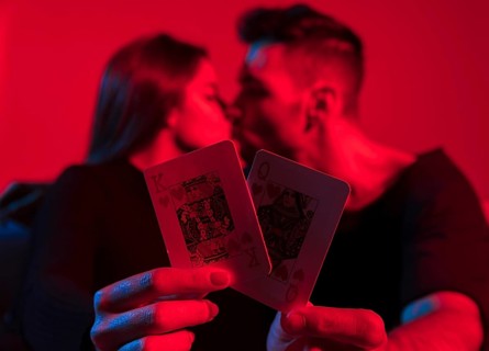 Couple holding king queen hearts playing cards hands