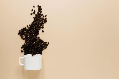 Cup with coffee beans copy space