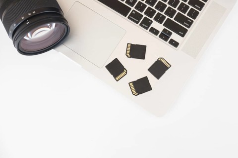 Elevated view dslr camera memory cards laptop keyboard