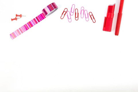 Elevated view pushpins paper clips cello tape markers white background