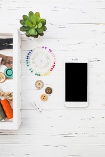 Elevated view smartphone clothes peg button sewing pin wooden background