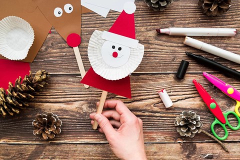 Elevated view woman s hand holding santa claus prop table