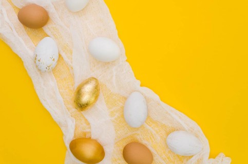 Flat lay eggs easter with gold paint textile