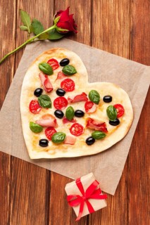 Flat lay heart shaped pizza wooden table