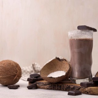 Front view chocolate coconut milkshake glass with copy space