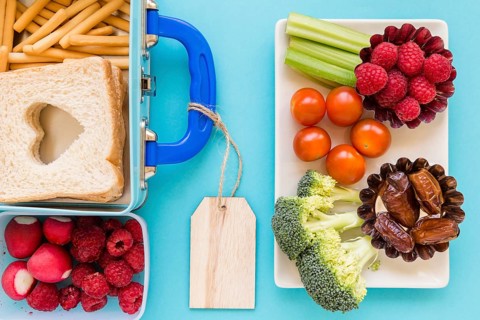 Fruits vegetables near nice lunchbox