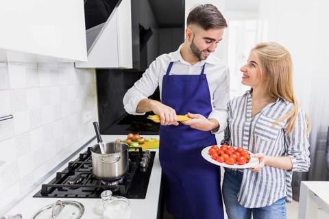 Happy couple putting spaghetti pot with boiled water