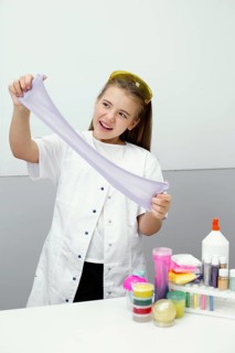 Happy young girl scientist making slime