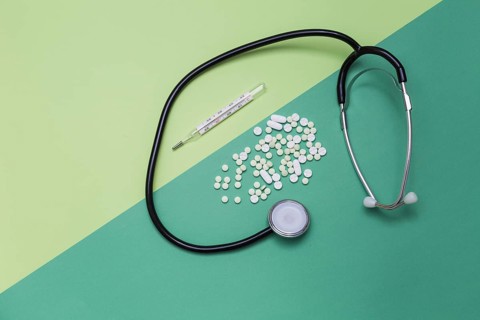High angle view medicines thermometer stethoscope dual colored background