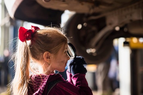 Little girl looking through magnifier