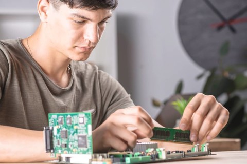 Male it technician inserting ram memory computer motherboard