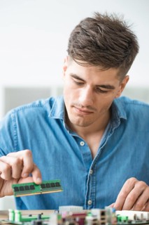 Male technician installing ram computer motherboard