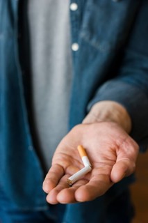 Man holding broken cigarette his hand