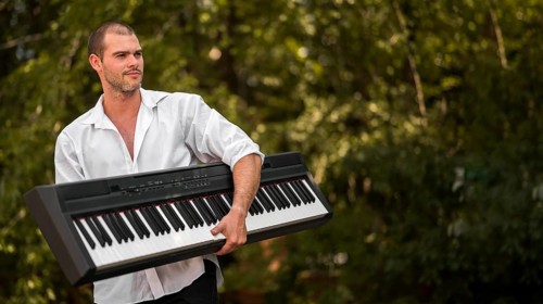 Man holding his digital piano outdoors