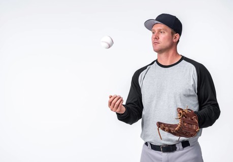 Man playing with baseball holding glove
