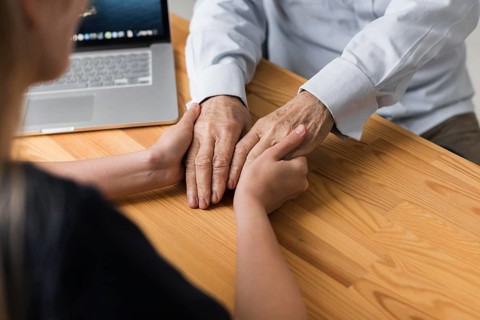 Nurse holding senior man s hands relief