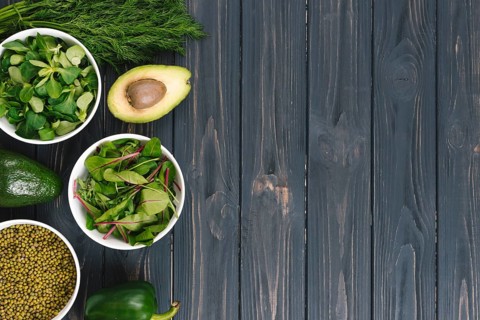Overhead view green vegetables black wooden desk
