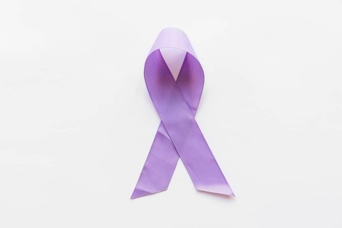 Overhead view purple awareness ribbon white background