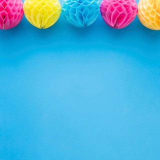 Pink yellow honeycomb pom pom paper balls decoration blue background