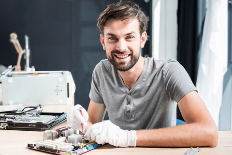Portrait happy man repairing circuit board computer