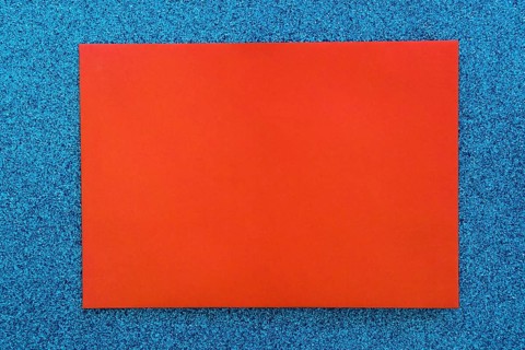 Red cardboard paper blue glitter background