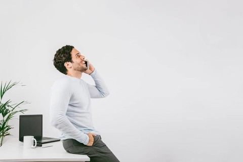 Smiley young man office talking phone