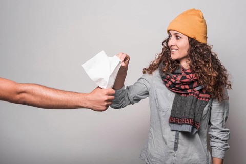 Smiling sick woman taking tissue paper from man s hand