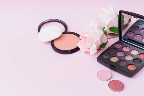 Sponge with blusher pink rose eyeshadow palette colored background