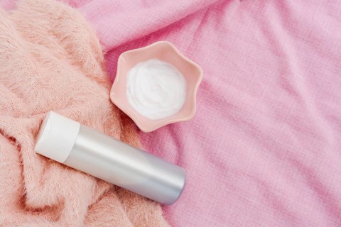 Top view bottle body butter pink background