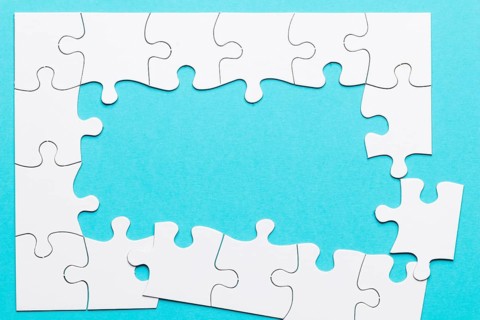 Top view incomplete puzzle frame blue backdrop